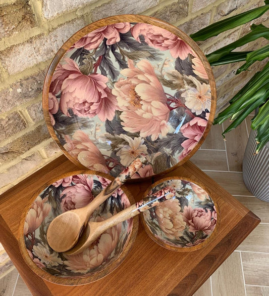small, Medium and large bowl with matching salad servers. This design features unfurling peonies in dusty rose pink & cream hues. Also featuring subtle tones of grey & green. Made from sustainable mango wood