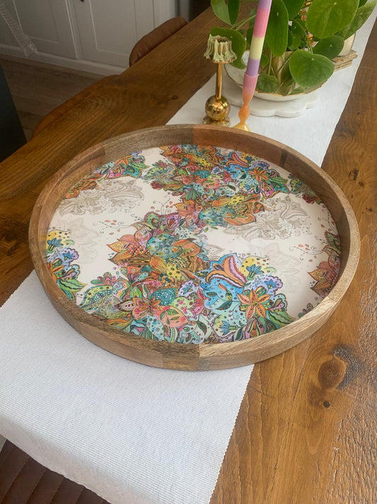 Multi-coloured floral pattern on a tray made from sustainable mango wood.