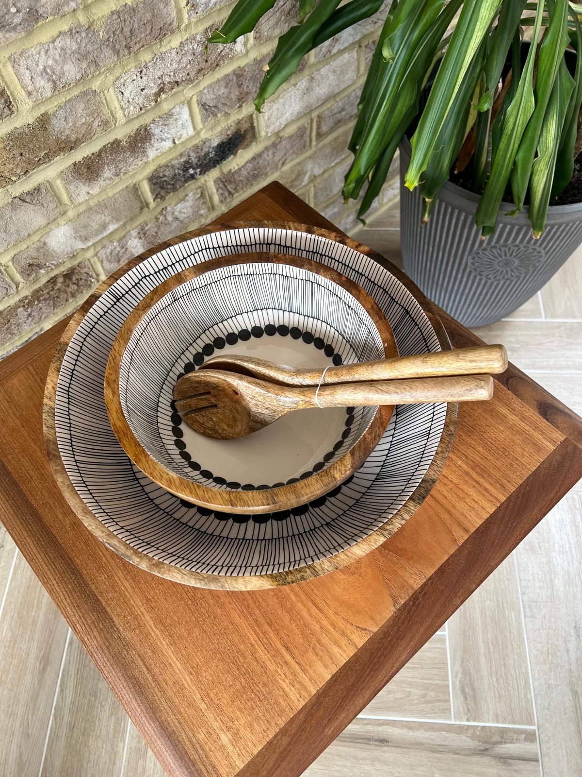 2 wooden bowls and matching salad servers.  Bowls Decorated with a black and white abstract circles design.  Medium and large sized bowls with plain salad servers.  All made form sustainable mango wood