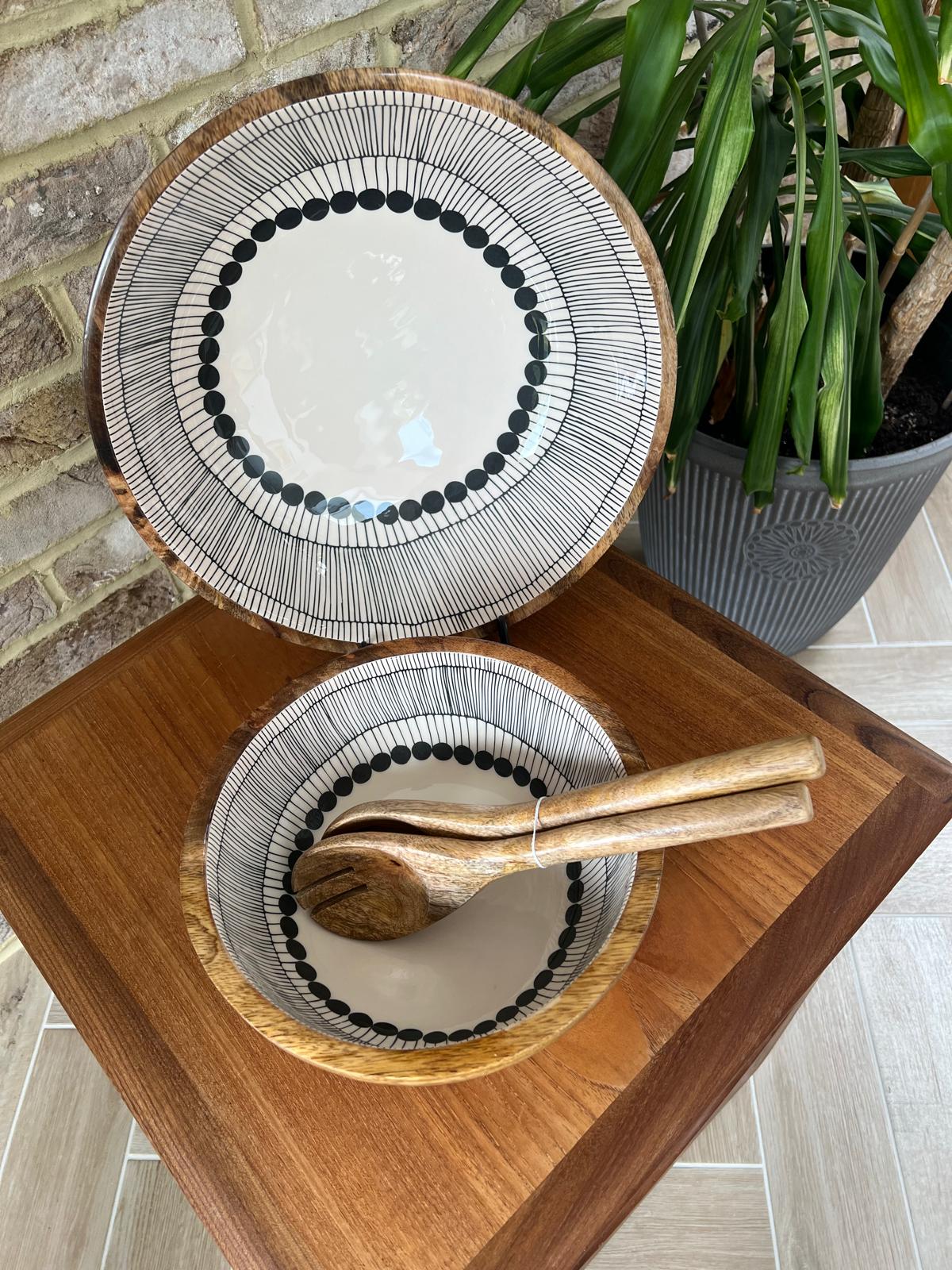2 wooden bowls and matching salad servers.  Bowls Decorated with a black and white abstract circles design.  Medium and large sized bowls with plain salad servers.  All made form sustainable mango wood