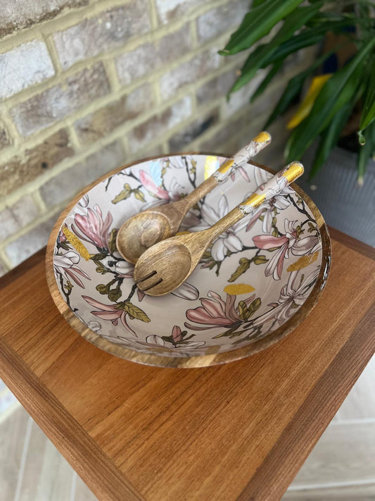 Large statement bowl made from sustainable mango wood with matching salad servers.  Featuring gold foil accents and magnolia flowers