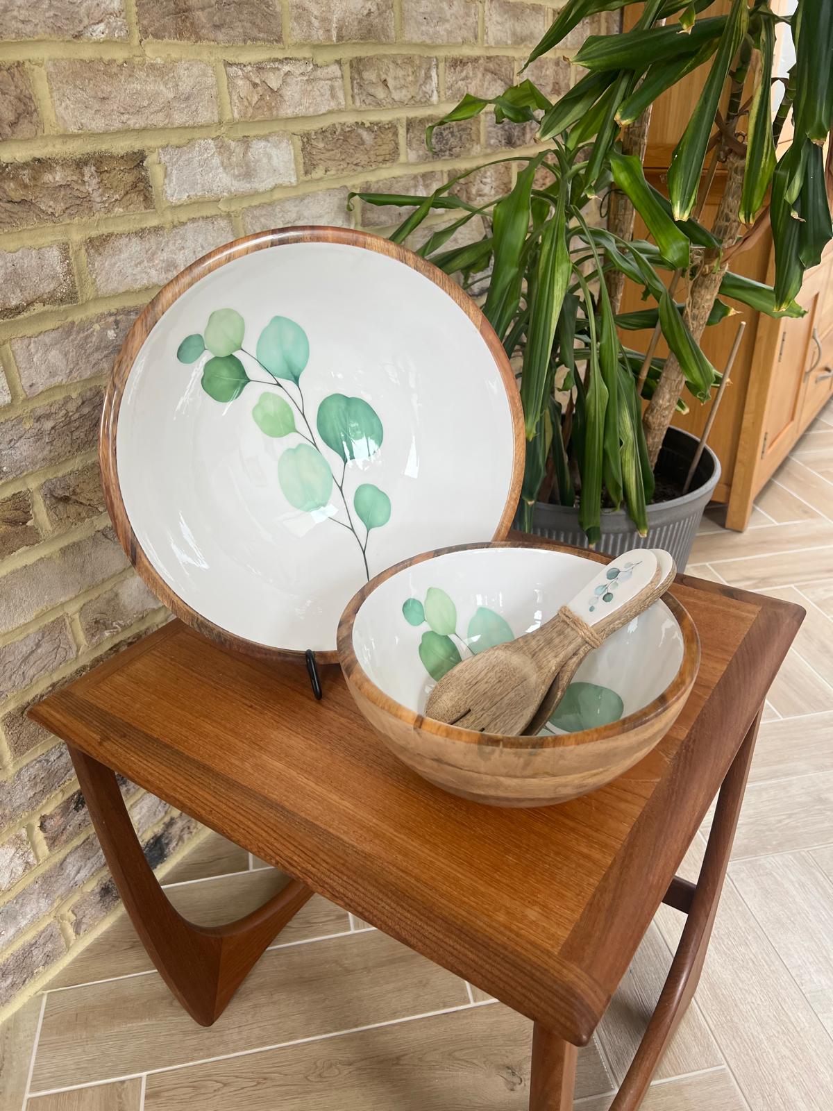Set of 2 bowls, medium and large with matching salad servers.  Round large sized bowl with green eucalyptus leaf design on a white background.  With matching salad spoon and fork.  Suitable for cold and warm food.  Salad bowl. Bowl sizes 25cm & 35cm diameter.  Made from sustainable mango wood.