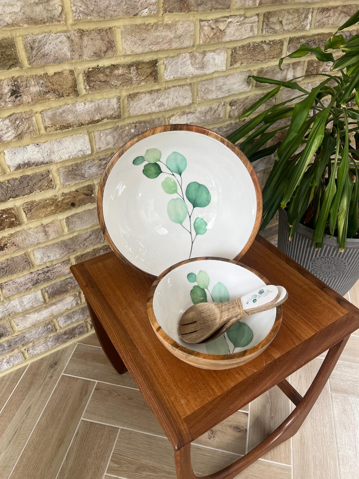 Set of 2 bowls, medium and large with matching salad servers.  Round large sized bowl with green eucalyptus leaf design on a white background.  With matching salad spoon and fork.  Suitable for cold and warm food.  Salad bowl. Bowl sizes 25cm & 35cm diameter.  Made from sustainable mango wood.
