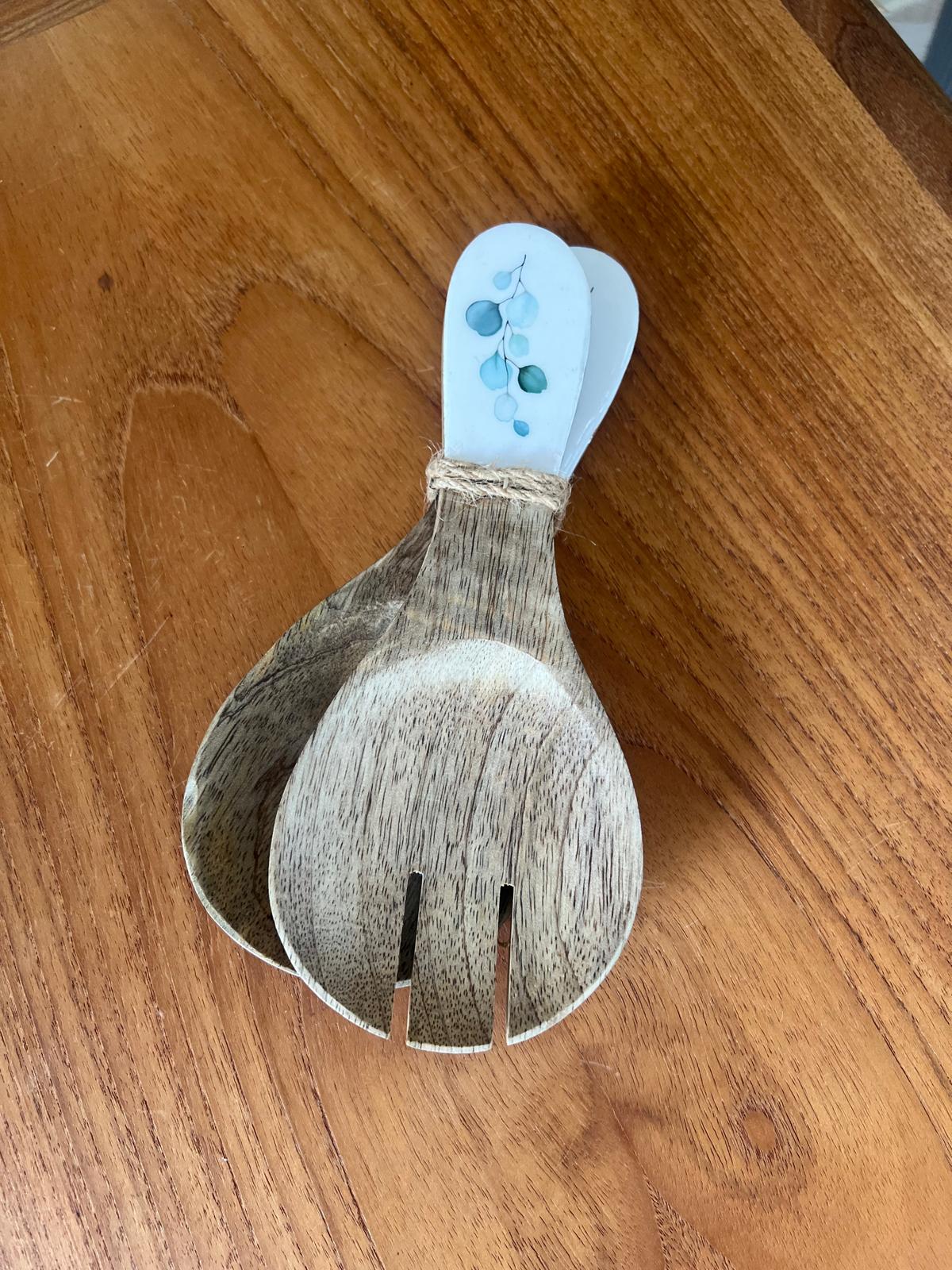 Wooden spoon and fork with a decorated handle featuring white background and eucalyptus leaf design.  Made from sustainable mango wood.  made to match our salad bowls