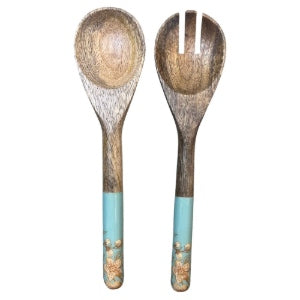 Two wooden spoons with decorated handles with a teal accent and magnolia flowers on a white background