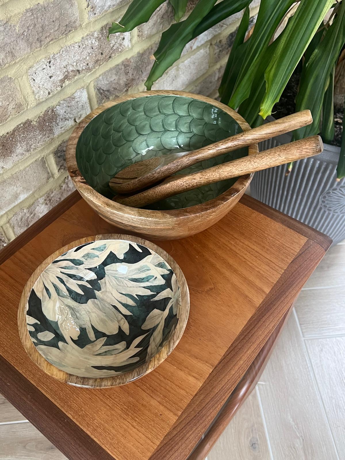 Small wooden bowl with floral design.  Background colour an inky blue, green, black.  With finger like leaf pattern.  Alongside a medium size hand painted wooden bowl in an Olive Green colour with pearl finish and fishscale design.  Made of sustainable mango wood and suitable for cold and warm food.