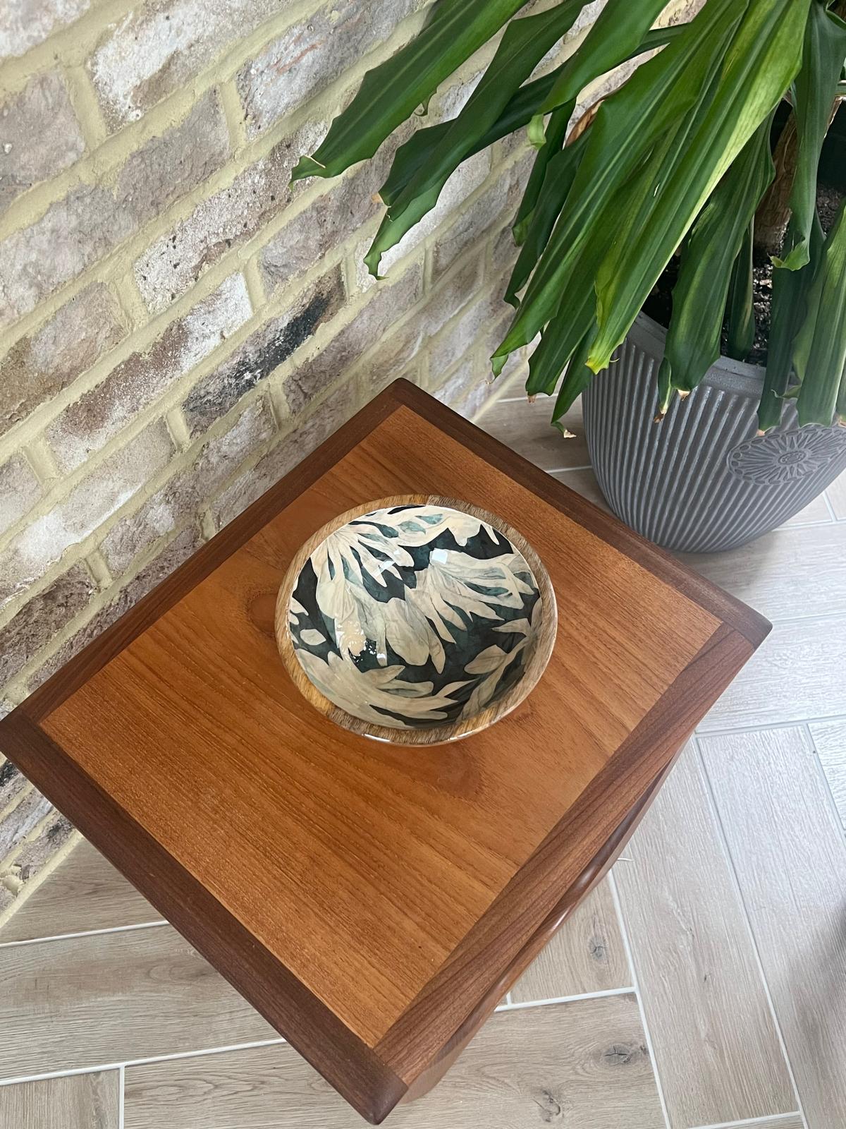 Small wooden bowl with floral design.  Background colour an inky blue, green, black.  With finger like leaf pattern.  Made of sustainable mango wood and suitable for cold and warm food.