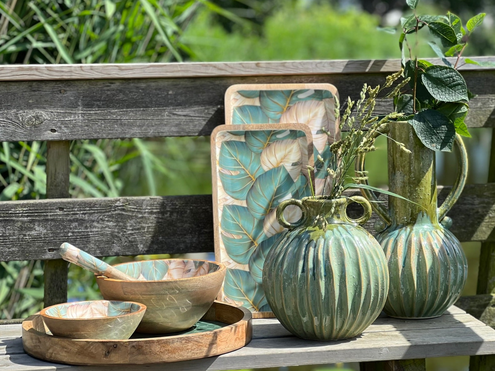 lifestyle shot. Medium and large platter - suitable for cold and warm food.  This beautiful design features monstera (aka cheese plant) leaves in green & golden beige; The ideal gift for anyone who loves house plants!!  Made from sustainable mango wood