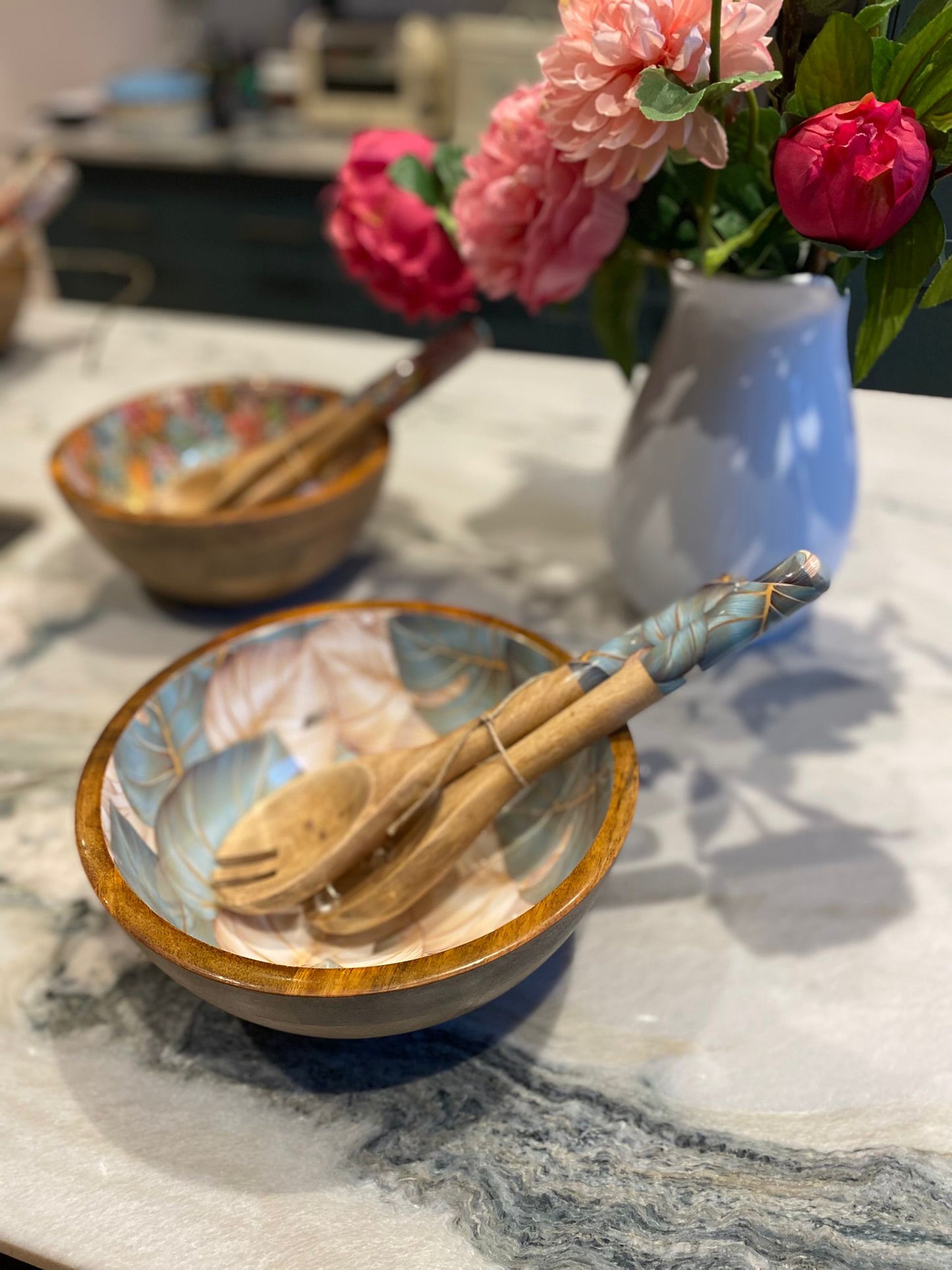 Medium bowl with matching salad servers.  This design features monstera aka cheese plant leaves in green and beige colours. Made from sustainable mango wood. 
