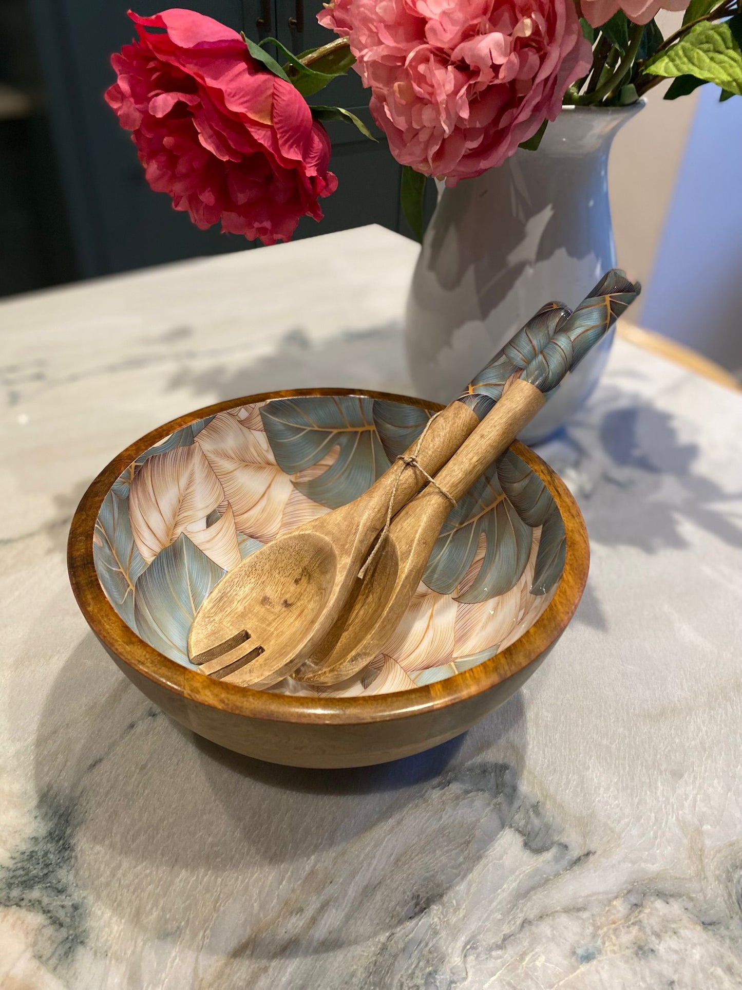 Medium bowl with matching salad servers.  This design features monstera aka cheese plant leaves in green and beige colours. Made from sustainable mango wood. 